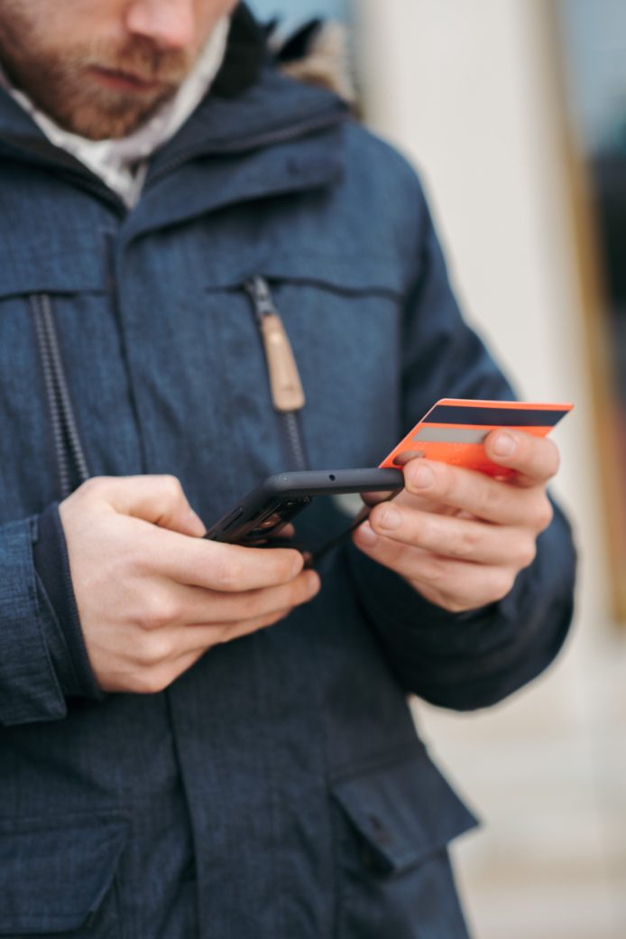 Photo by Anete Lusina: https://www.pexels.com/photo/anonymous-guy-with-plastic-card-making-online-payment-using-smartphone-on-street-6353659/