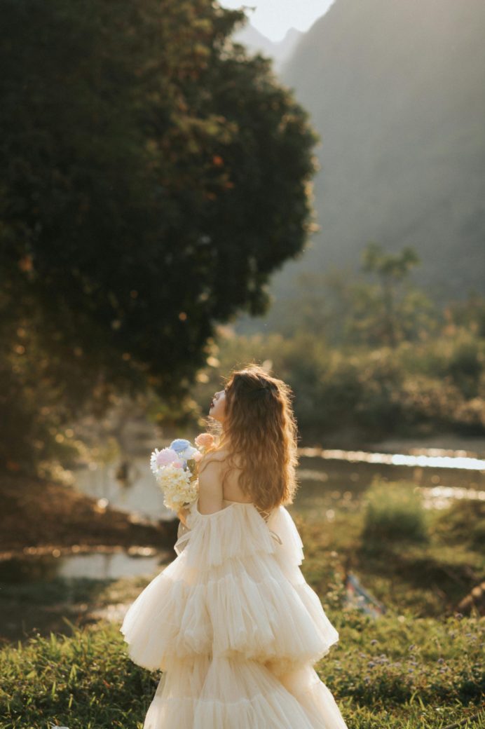 Photo by Chuotanhls  : https://www.pexels.com/photo/woman-in-a-tulle-dress-holding-flowers-18426425/