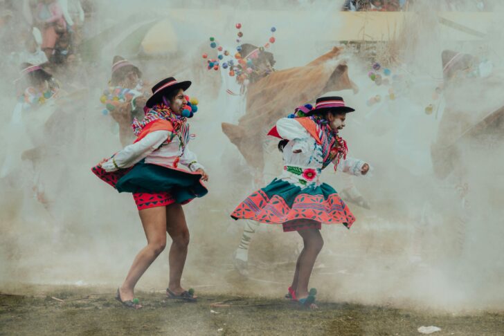 Photo by Alejandro Novoa: https://www.pexels.com/photo/people-dancing-in-traditional-clothing-on-festival-16756546/ illustration of the Indian market at Pisac